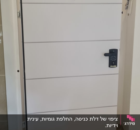 דלת לבנה עם ידית שחורה ומנעול דיגיטלי